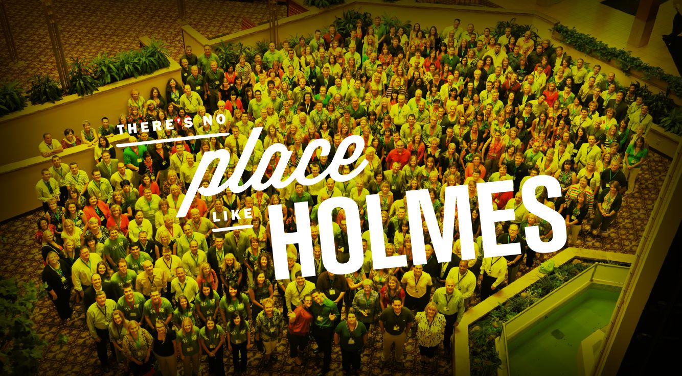 a group of Holmes Murphy employees with text 'there's no place like Holmes' across the top