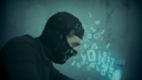 A cyber thief dressed in black stealing data
