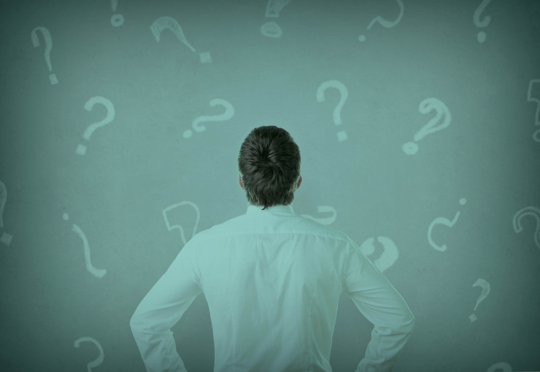 A person staring confused at a wall with question marks.