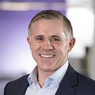 Jay Reavis - a man in a blazer and collared shirt smiling at for a professional photo