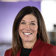 Kari Cooling - a woman in a red blazer smiling in a professional headshot photo