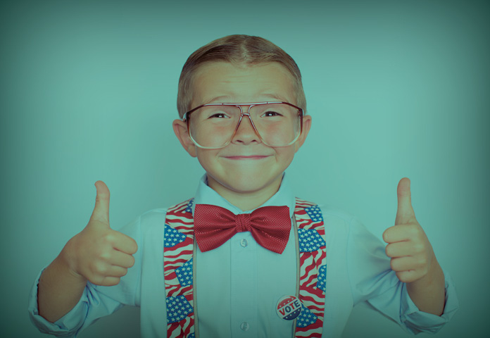 boy dressed in red, white, and blue suspenders and bow tie