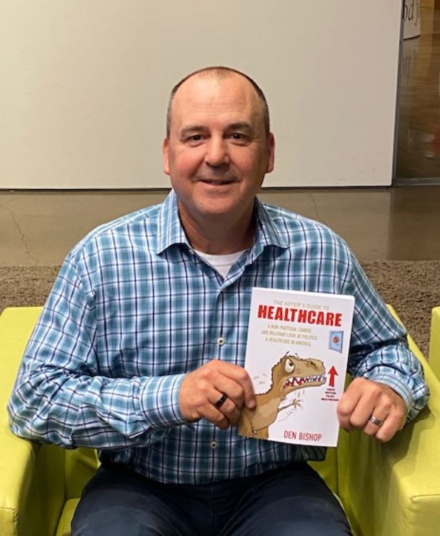 Den Bishop with a copy of his book "The Voter's Guide to Healthcare."