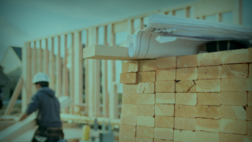 A man constructing a commercial building with timber.