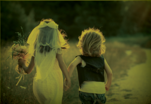 Children dressed as a bride and groom running away from the camera