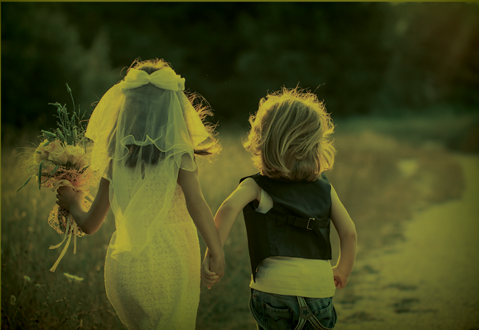 Children dressed as a bride and groom running away from the camera