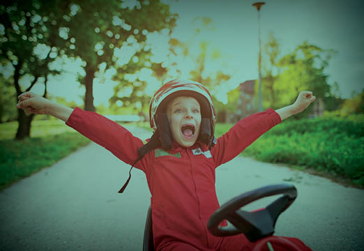 A child happily playing in a car