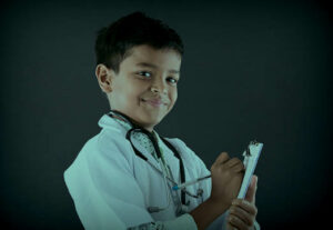 a boy pretending to be a doctor in healthcare
