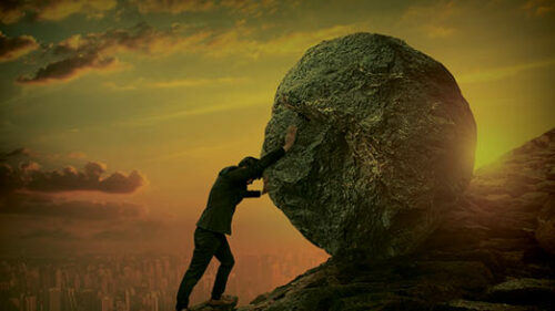 A man pushing a rock up a hill