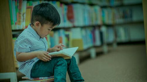 A boy reading a book on healthcare