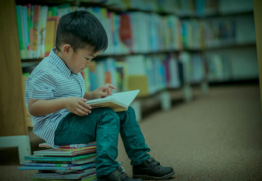A boy reading a book on healthcare