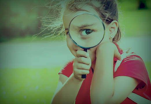 A child looking through a magnifying glass