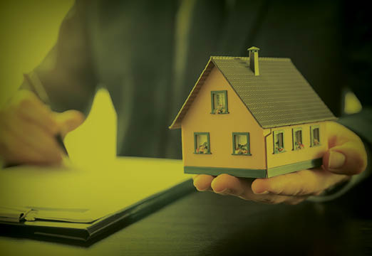 a toy house with homeowners insurance paperwork