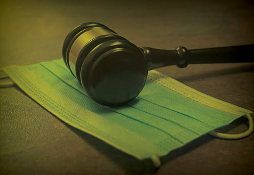 A gavel with a protective face mask