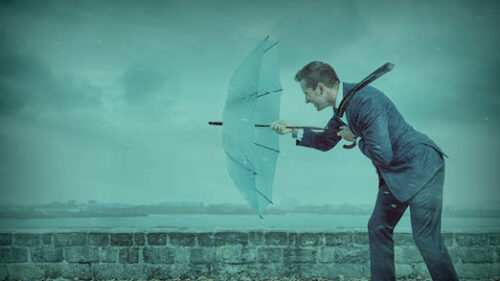 A man walking against a rain storm