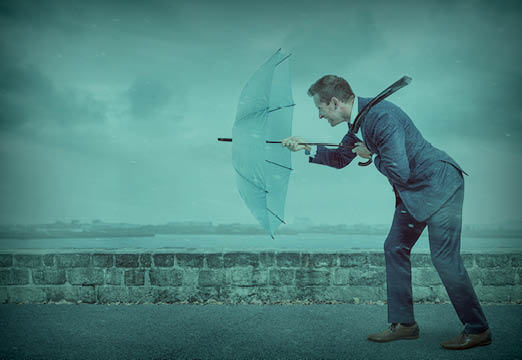 A man walking against a rain storm