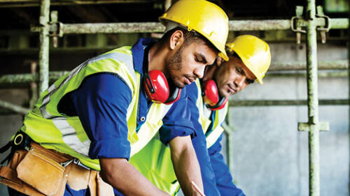 Construction workers consulting blue prints