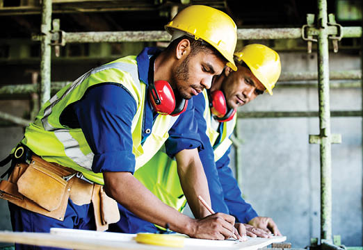 Construction workers consulting blue prints
