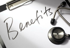 The word benefits scrawled across a clipboard next to medical equipment
