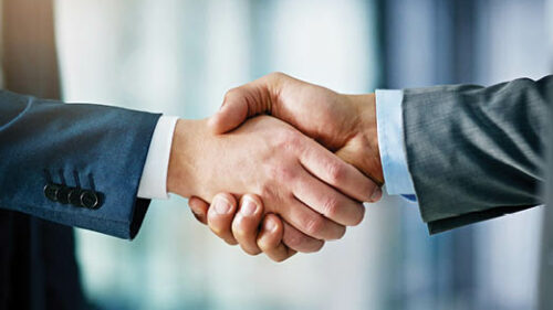 Two business professionals in suits shaking hands
