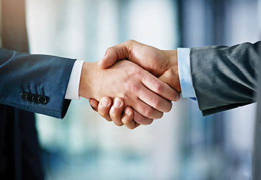 Two business professionals in suits shaking hands