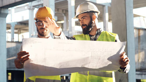 Construction workers examining a blueprint on a jobsite