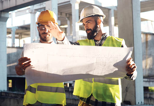 Construction workers examining a blueprint on a jobsite