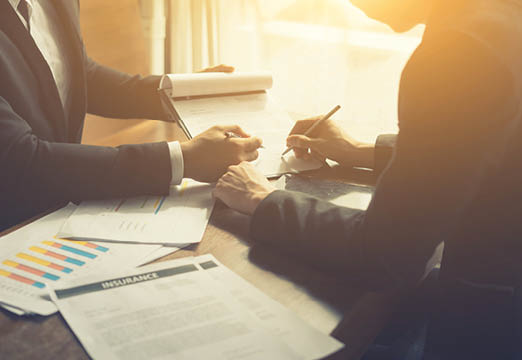 Two people talking over insurance paperwork