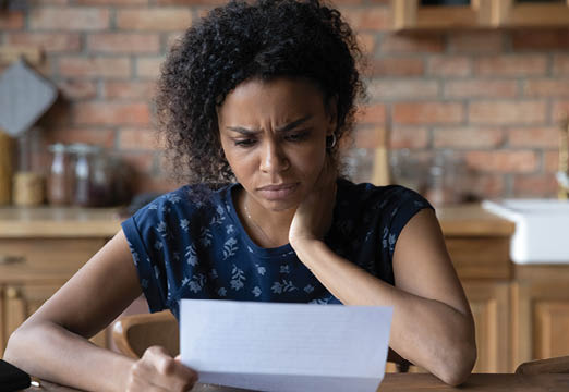 A woman looking confused at a piece of paper