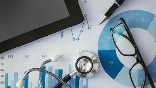 healthcare equipment on a desk with graphs and glasses