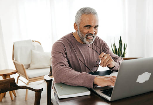 An older employee working from home on his laptop