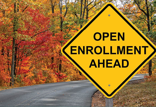 A road sign that says Open Enrollment Ahead on a fall scenic road