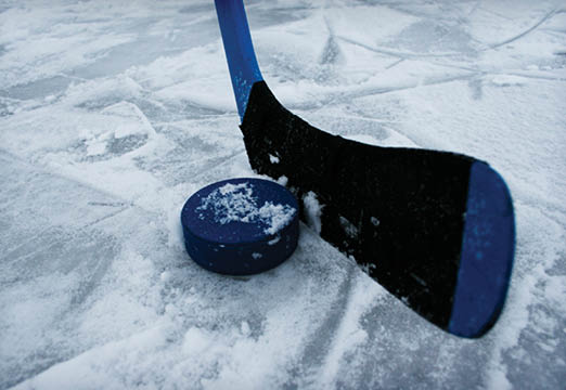 A hockey stick and a puck on ice