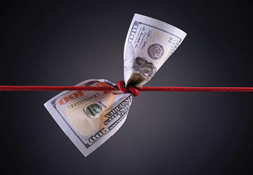 A 100 dollar bill tied up by a red rope.