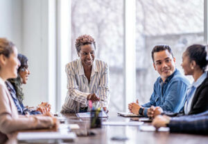 Business professionals sitting around a conference table discussing latest insurance trends.