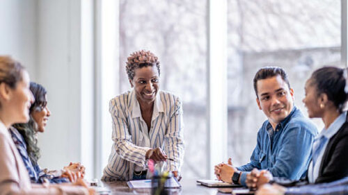 Business professionals sitting around a conference table discussing latest insurance trends.