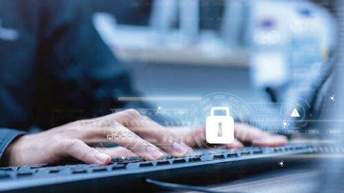 A professional typing on the computer with a lock