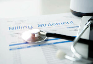 A medical bill with a stethoscope resting on top