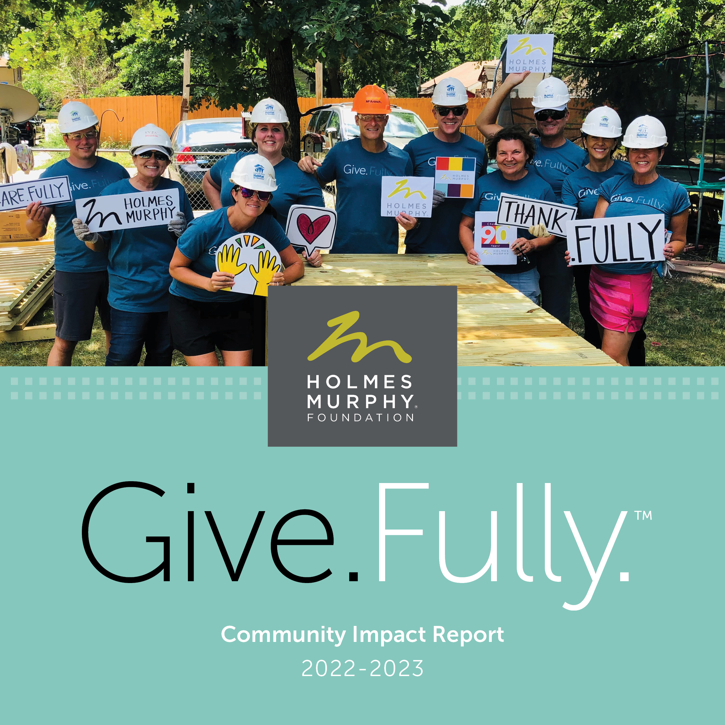 A smiling group of Holmes Murphy employees with hard hats on with the text: Give.Fully. Community Impact Report 2022-2023