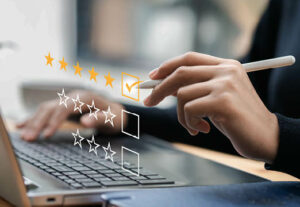 A person typing a 5 star review on a laptop.