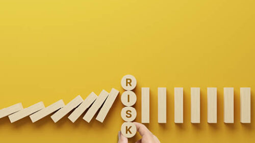A yellow background with wooden blocks and the word Risk.