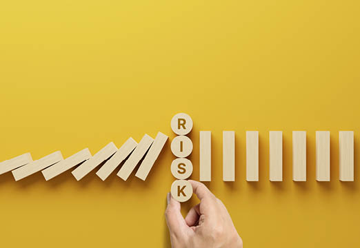 A yellow background with wooden blocks and the word Risk.