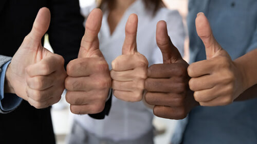 Multi-cultural people with their thumbs up as a team.