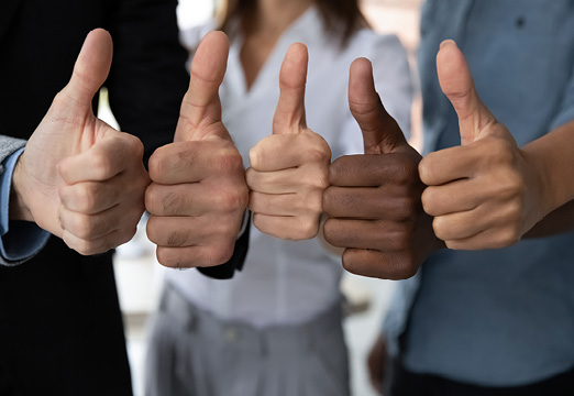 Multi-cultural people with their thumbs up as a team.