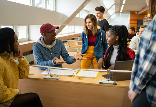 A group of diverse college students working on a project together in a lecture hall.