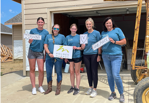 A group of 5 Holmes Murphy employees from the Sioux Falls office wearing Give.Fully. shirts at a volunteer event in 2023.
