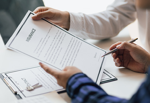 Business professionals holding insurance paperwork.