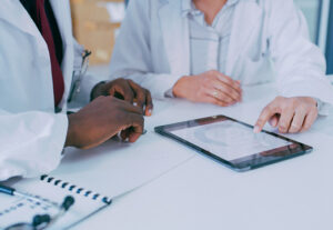 Two healthcare professionals talking over a table.