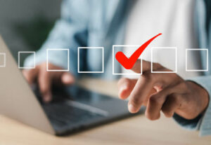 A man in professional dress touching on of many illustrated box to create a check mark.