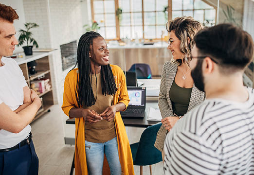 Diverse group of employees talking together pleasantly.